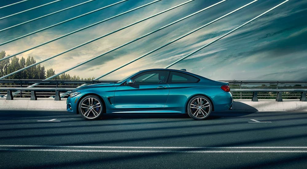 A teal 2020 BMW 4Series coupe is shown from the side on a bridge near Cincinnati, OH.