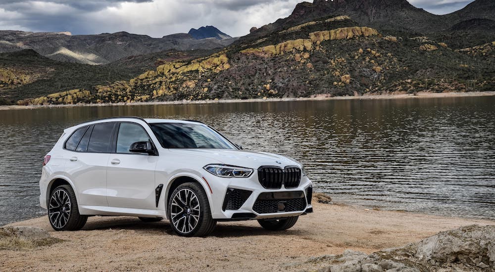 A white 2020 BMW X5 M is parked in front of a pond outside Cincinnati.