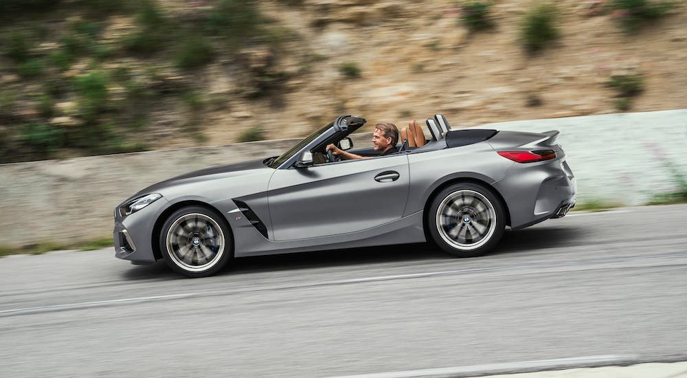 A silver 2021 BMW Z4 is shown from the side driving on a highway.