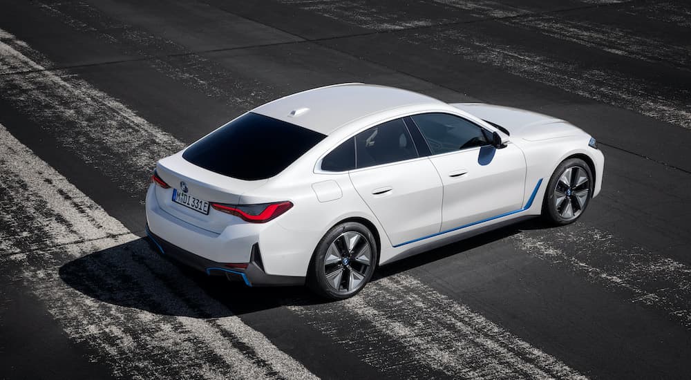 A new BMW EV, a white 2022 BMW i4 Xdrive40, is shown from a high angle parked on pavement.