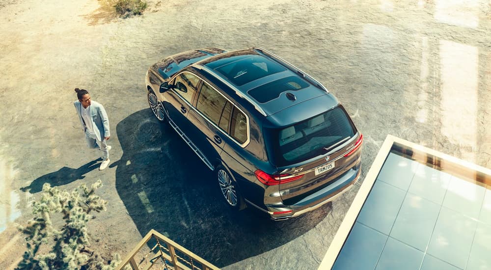 A black 2022 BMW X7 Alpina is shown from a high angle in a driveway.