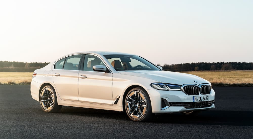 A person is shown driving a white 2017 used BMW 5 Series in Cincinnati.