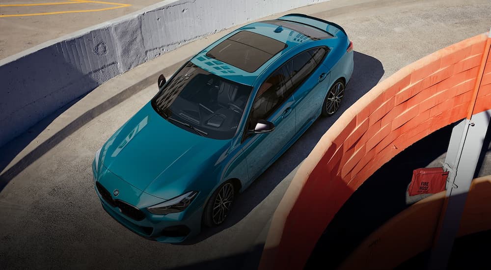 A blue 2022 BMW 2-Series Gran Coupe is shown from a high angle leaving a Sharonville BMW dealership.