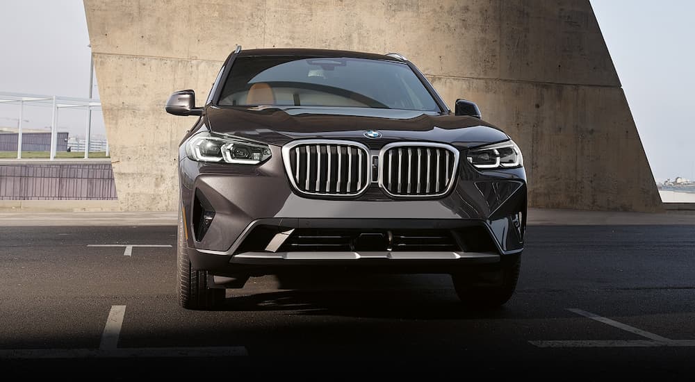A black 2022 BMW X3 is shown from the front parked in an empty lot.