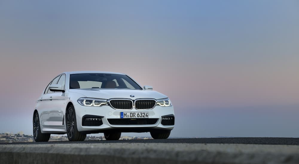 A white 2016 BMW 5-Series M Sport is shown parked near a used BMW dealer near you.