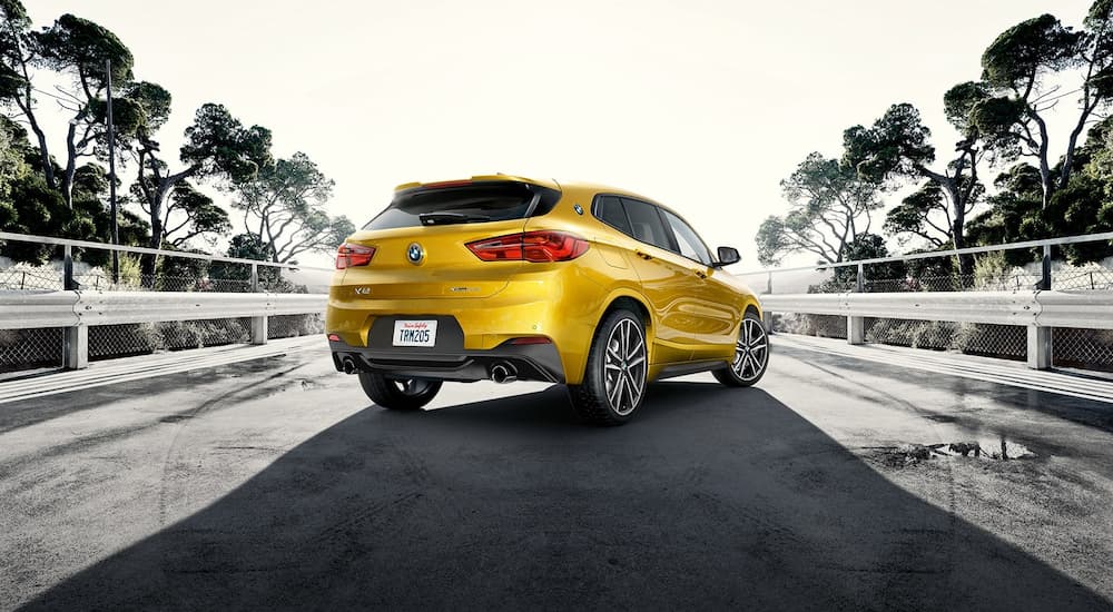 A yellow 2022 BMW X2 M35i is shown from the rear on a bridge.