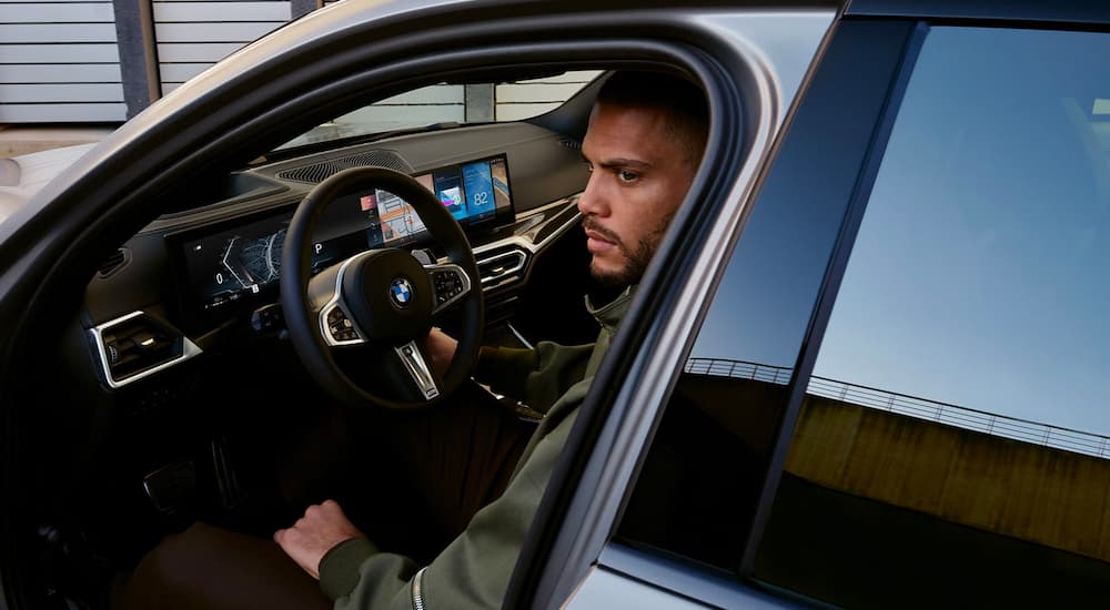 A person is shown sitting in a grey 2020 BMW 3 Series.