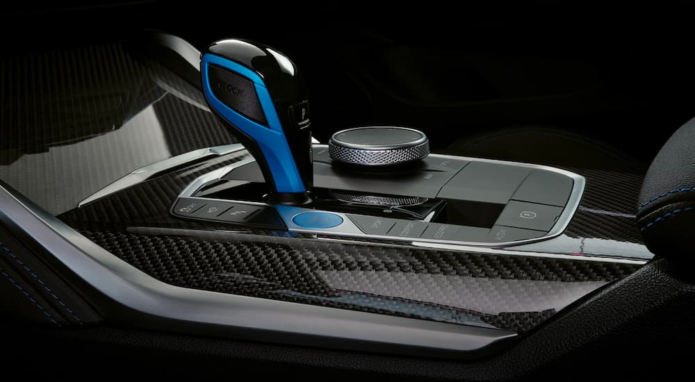 A close up shows the shifter and carbon fiber accents in a 2023 BMW i4.
