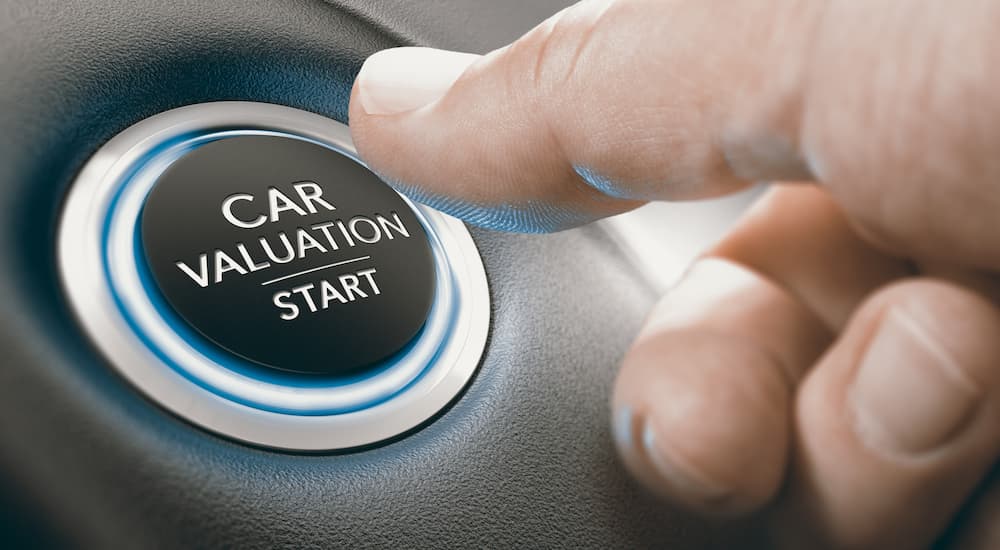 A thumb is shown pressing a button that says 'car valuation start.'